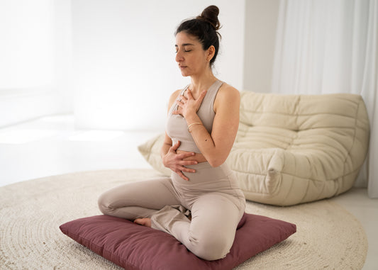 Frau meditiert auf Meditationskissen: Meditation gegen Stress - Lotsucrafts